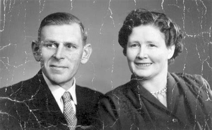 an old black and white photo of a woman in a dress with curly hair